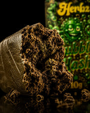 Herbz Bubble Hash con superficie oscura y perfil natural de hachís